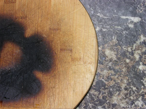 Charred cutting Board made of natural wood, which is intricately burned from flame of gas burner. The material of the Board is cut, cracked, punctured, decrepit, stained black. About this kitchen utensils is master can get dirty as chimney sweep.