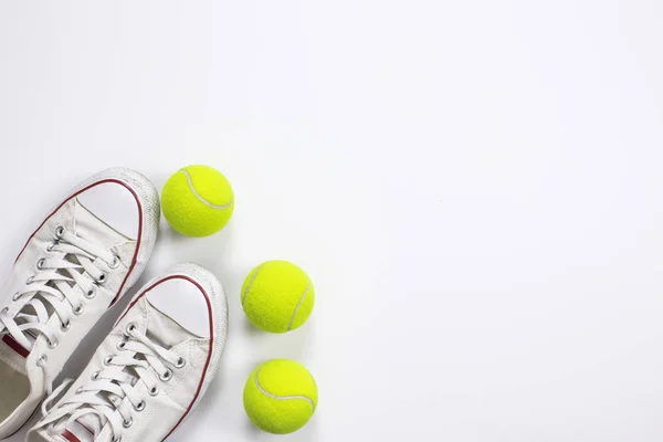 Pelotas de tenis y zapatos aislados de fondo. Vista superior — Foto de Stock