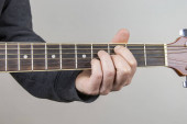 Kytarista Hand nebo hudebník Hand in jazz Chord on Acoustic Guitar