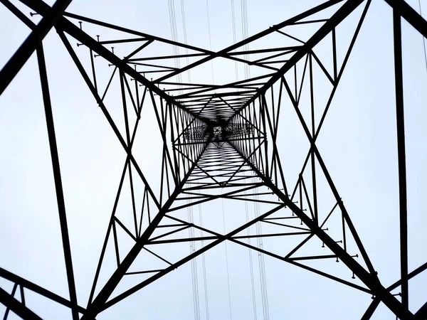Looking up an Electrical Pylon with clear blue sky
