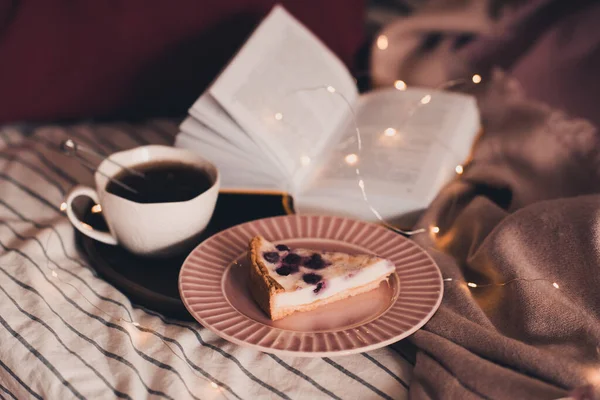 Cup Black Tea Tasty Fruit Cake Open Book Glowing Lights — Stock Photo, Image