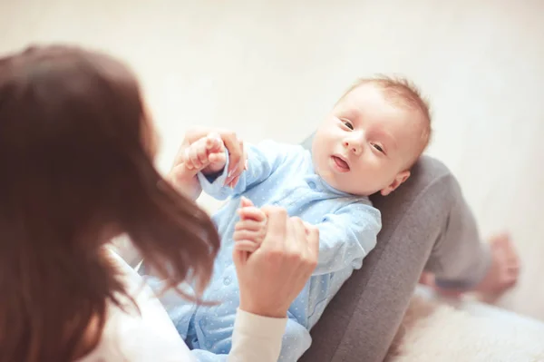 可爱的男婴在房间里靠母亲的腿躺着 牵着新生的手的女人母性 — 图库照片