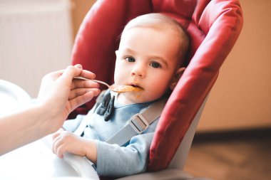 Bebek içeride kaşıkla elma püresi yiyor. Kameraya bakıyorum. Çocukluk.