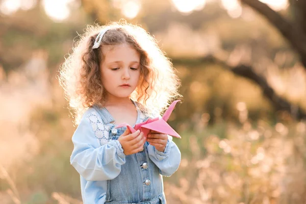 Sarışın Kız Yaşlarında Elinde Kağıt Origami Vinç Doğa Arka Planının — Stok fotoğraf