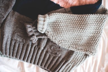 İki örgü süveter yatak manzarasında katlanmış. Kış mevsimi konsepti. 