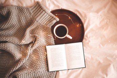 Süveter örüp, bir fincan kahve ve açık bir kitap kapağı yaptım. Kahvaltı vakti geldi. İyi sabahlar. Kış tatili. 