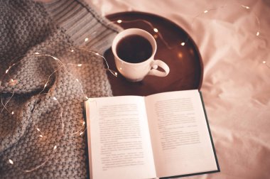 Beyaz çay, açık kitap ve yakın çekimde örülmüş forma. Kış tatili. Kahvaltı. İyi sabahlar. Kahvaltı zamanı..