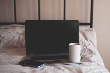 Evde dizüstü bilgisayar, foe ve bir fincan kahveyle çalışma odasında. Evde kal. Karantina zamanı. İyi sabahlar. Sosyal uzaklık. 