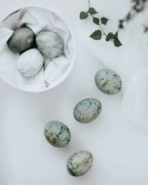 Chrestian Easter traditions. Painting Easter eggs. Easter eggs. Easter home decor. Stylish coloring of eggs. Minimalism in the Easter decoration. Life style. Vera. Religious traditions. Branches with buds. Eggs in a round white box