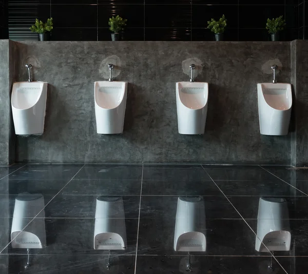 Белые писсуары керамические в мужской ванной комнате — стоковое фото