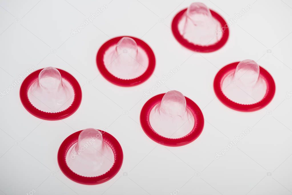 Rolled latex condom on white background