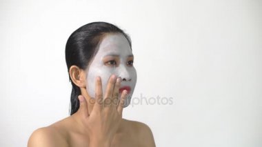 Genç kadın kil yüz maskesi peeling maskesi yüzünde beyaz arka plan üzerinde arıtma ile doğal