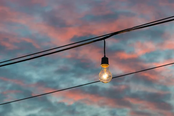 Light bulb glowing on sunset background — Stock Photo, Image