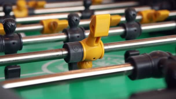 Close-up jogadores amarelos, jovem jogando desfrutar de matraquilhos jogo de futebol de mesa de madeira — Vídeo de Stock