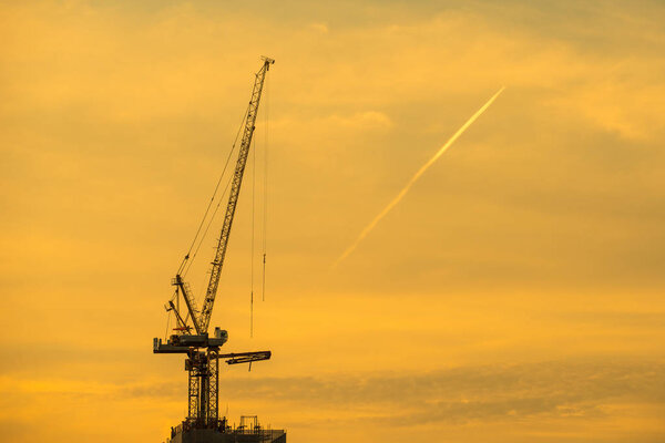 Sunset and silhouette of the crane operating