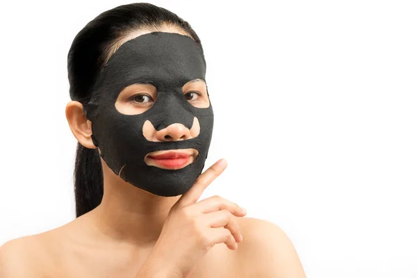 Junge Frau macht schwarze Gesichtsmaske mit reinigender Maske auf — Stockfoto