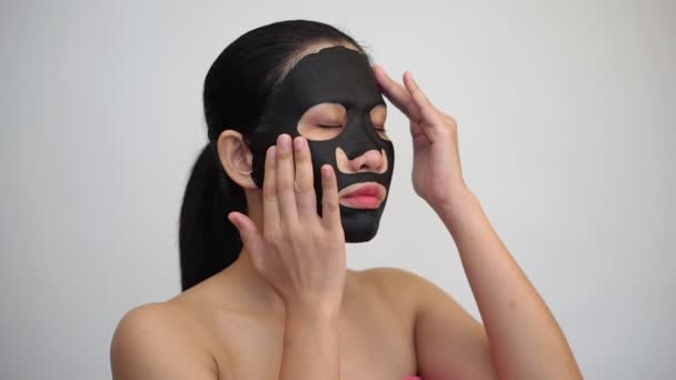 Young Woman Doing Facial Black Mask Sheet Purifying Mask Her — Stock Video