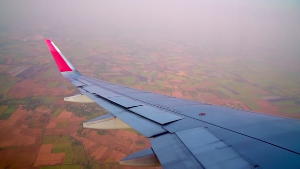 Letadlo vznáší se na obloze v přízemí se zemědělskými podlahami. — Stock video