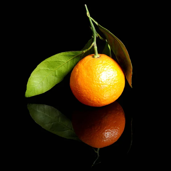 Mogen saftig apelsin mandarin med blad isolerade på en blank svart bakgrund med reflektion — Stockfoto