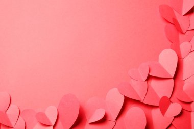 Kırmızı arkaplandaki kırmızı kağıt kalplerden kes