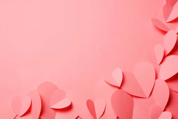Вырезанные из розовой бумаги сердца на розовом фоне . — стоковое фото