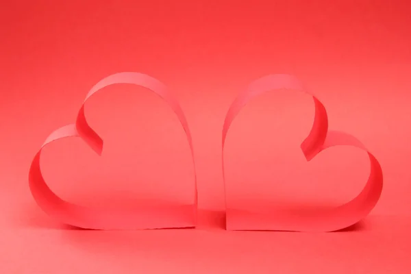 Paire de coeurs en papier rouge sur fond rouge vue de côté — Photo