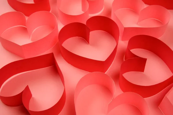 Куча красных и розовых бумажных сердец на розовом фоне — стоковое фото