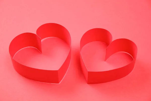Pair of red paper hearts on red background Stock Image