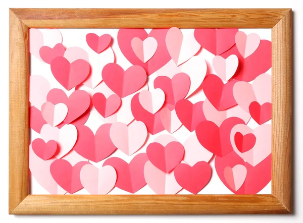 Wooden frame with red and pink paper hearts cutouts on white background — Stock Photo, Image