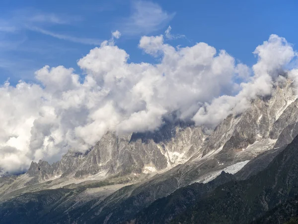 Awan cumulus padat menutupi puncak-puncak pegunungan Alpen. Lereng pegunungan yang curam, tak dapat dilewati . — Stok Foto