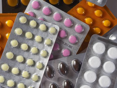 Kabarcıklardaki farklı şekillerde ve farklı renklerde tabletler arkaplanı doldurur.