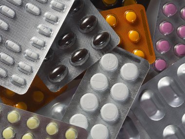 Kabarcıklar ve ilaçların geçmişi. Farklı renk ve şekillerden oluşan tablet paketleri üst üste konur. Çeşitli hastalıklar için ilaçlar.