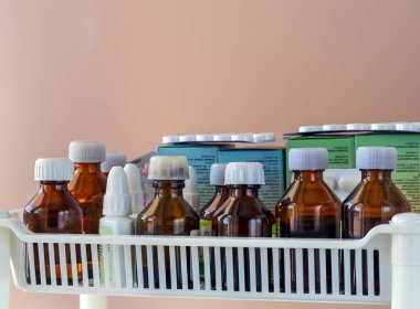 Eczanede, hastanede, laboratuvarda, klinikte, ecza dolabında konserve ve sıvı ilaç bulunan haplar. İş için tıbbi geçmiş.