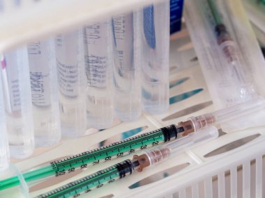 Tedavi odasının rafında şırınga ve serum fizyolojik var. İşletmeler, eczaneler, klinikler, hastaneler için tıbbi geçmiş.