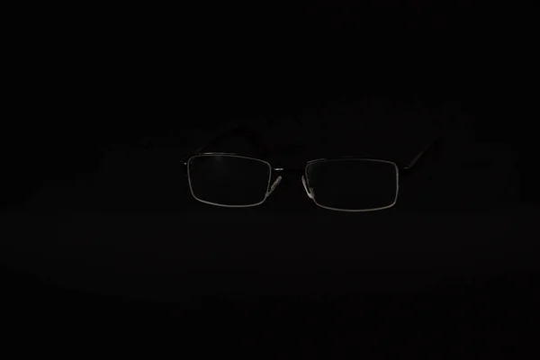 Vision glasses on black background. Take care of your eyes. Lenses. Poor vision.Copy space. Top view. Flat layout. Minimal background.