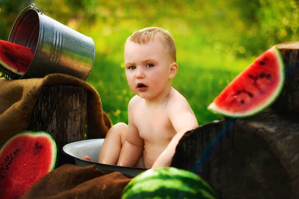 村里没有T恤衫的小孩的画像 在新鲜空气中 两岁的孩子在花园里的草地上吃西瓜 肮脏的脸 快乐多愁善感的孩子 多汁的西瓜 — 图库照片