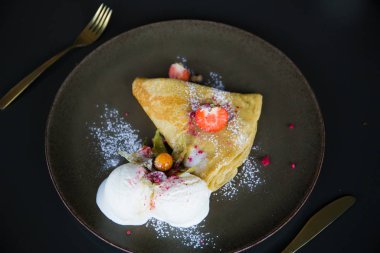 Çilekli krep ve dondurma, pudra şekerli.