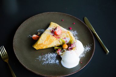 Çilekli krep ve dondurma, pudra şekerli.