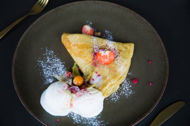 Çilekli krep ve dondurma, pudra şekerli.