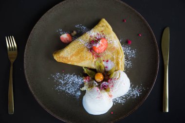 Çilekli krep ve dondurma, pudra şekerli.