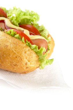 Hotdog beyaz zemin üzerine peçete üzerinde malzemelerle kırpılmış