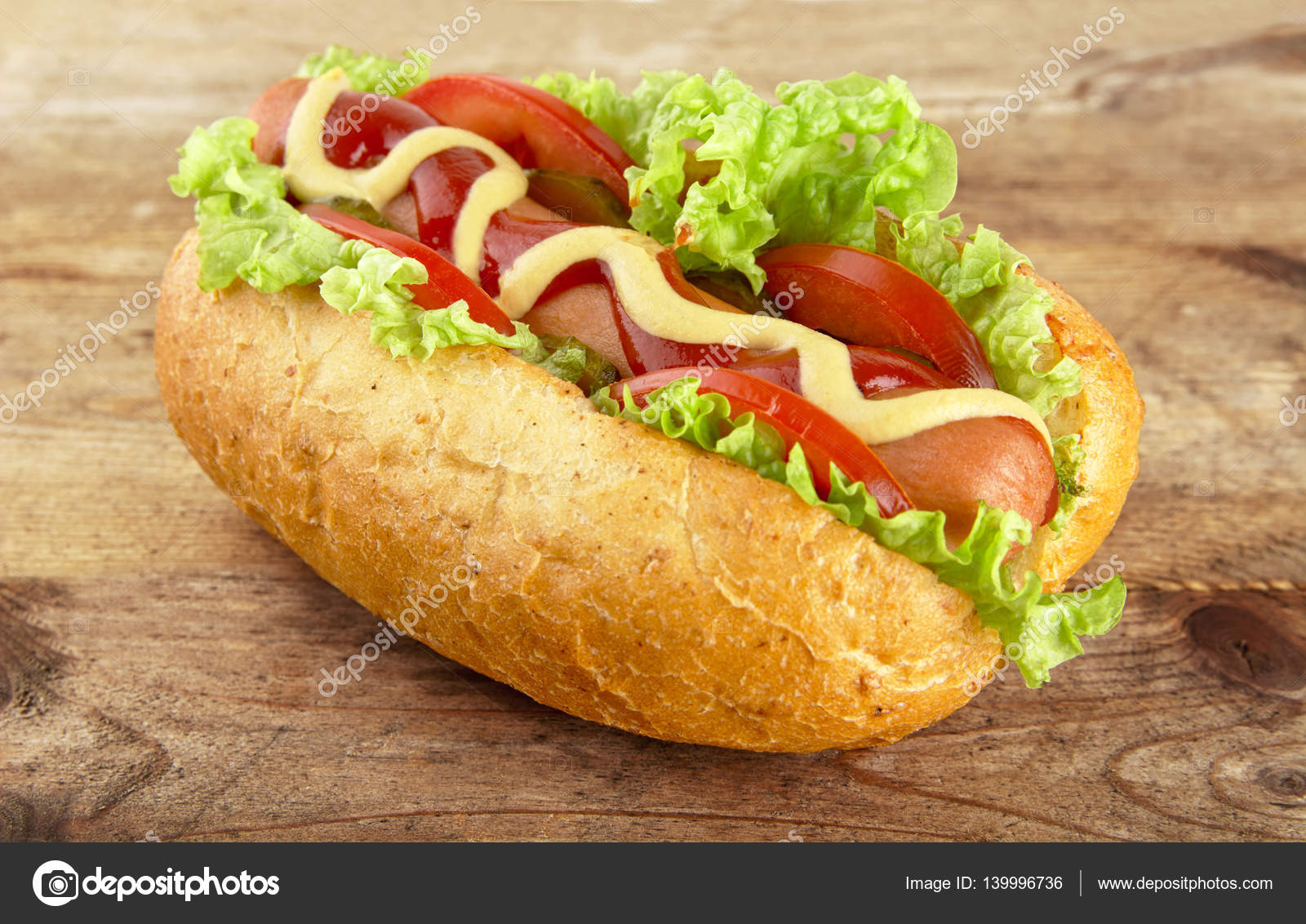 Hot Dog mit Salat, Tomaten und Gurken auf Holzbrett - Stockfotografie ...