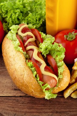 Sosisli domatesli ahşap tahta üzerinde arka planda