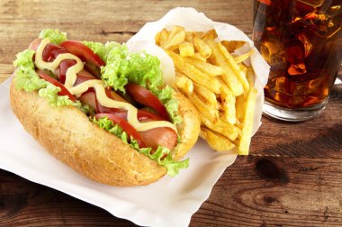 Tek hotdog kola tahta üzerinde tepsi üzerinde patates kızartması ile