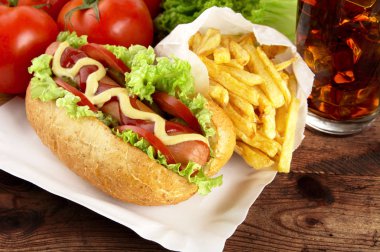 Tek hotdog kola tahta üzerinde tepsi üzerinde patates kızartması ile