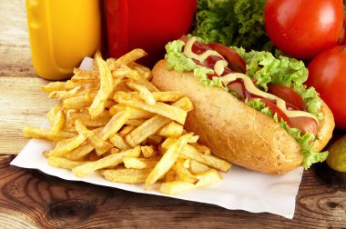 Tek hotdog tepsi tahta üzerinde patates kızartması ile
