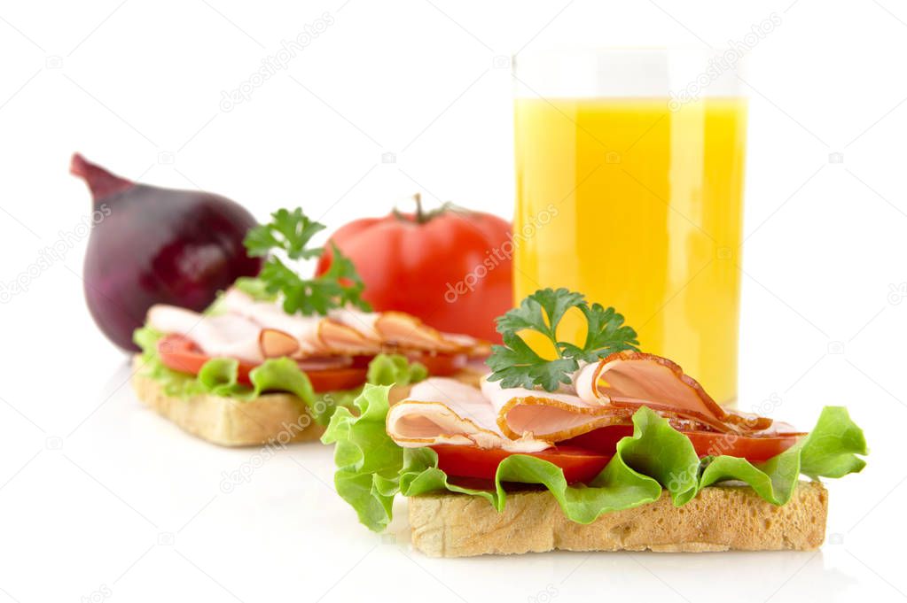 Toasts with cold cuts for breakfast break with orange juice on white