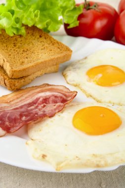 Dilim kızarmış domuz pastırması, iki yumurta kahvaltı tost ile plaka üzerinde