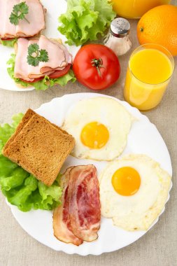 İki yumurta, sağlıklı öğle yemeği pastırma bir plaka üzerinde suyu ile tost ile 