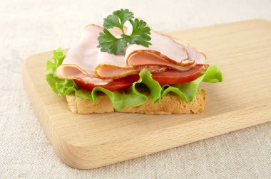 Tost, marul, domates, söğüş keten tableclo üzerinde kesme tahtası üzerinde